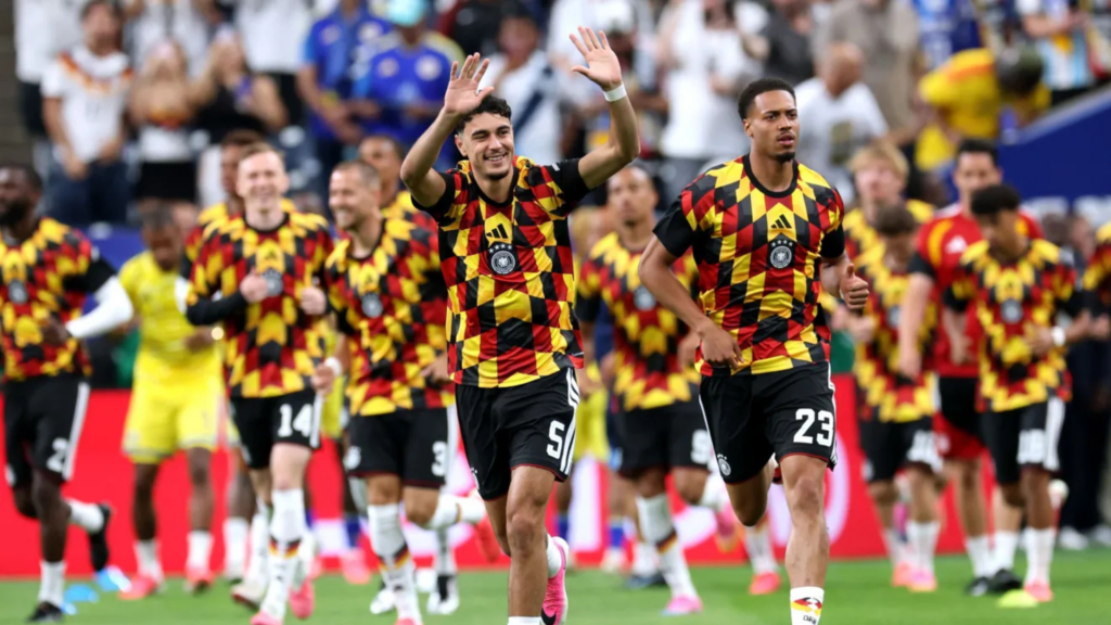 Aleksandar Pavlovic, Felix Nmecha e outros jogadores no aquecimento para a partida contra Curaçao • Alexander Hassenstein/Getty Images